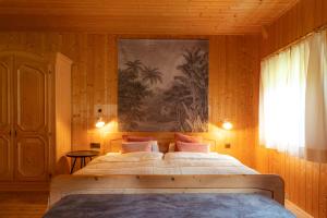a bedroom with a large bed with a painting on the wall at Bauernhaus Spathen in Santa Valburga St. Walburg