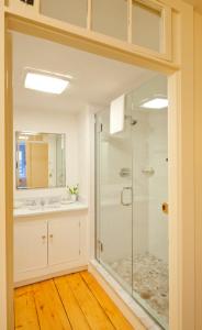 een badkamer met een glazen douche en een wastafel bij Union Street Inn in Nantucket