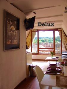 uma sala de jantar com uma mesa e uma janela com vista em FRANRÉAL, 4 Appartements em Sarlat-la-Canéda