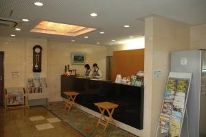 un restaurant avec 2 personnes assises à un comptoir dans l'établissement Kuretake-Inn Hamamatsu Nishi I.C., à Hamamatsu
