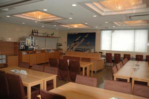 - un restaurant avec des tables et des chaises dans une salle dans l'établissement Kuretake-Inn Hamamatsu Nishi I.C., à Hamamatsu