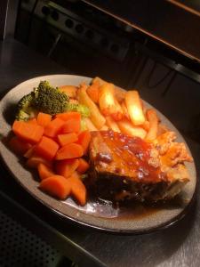 um prato de comida com carne e legumes no fogão em The Brewers Arms em Snaith