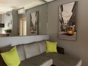 un soggiorno con divano e foto di un tram di Co&Mo bilocale adiacente Duomo a Milano