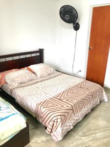 a bedroom with a bed with a brown and white comforter at Caribbean Venture Apto 802 - Rodadero, Santa Marta in Santa Marta