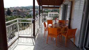 a balcony with a table and chairs on a balcony at HOUSE DILENA TSIMTSIRI in Limenaria