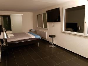 a hotel room with a bed and a television at Nice Apartment in Horgen near lake and Pool in Horgen