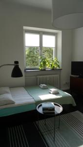 a bedroom with a bed with a table and two windows at Lovely Bubbly Apartment in Krakow