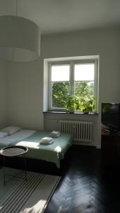 1 dormitorio con cama, ventana y mesa en Lovely Bubbly Apartment en Cracovia