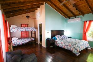 una camera da letto con due letti e un divano di Casita Océana a Sandy Bay