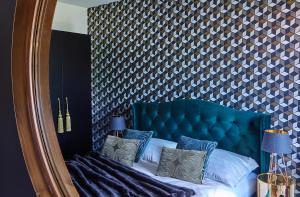 a bedroom with a blue headboard and a mirror at Apartament Berg in Szczyrk