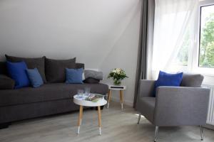 a living room with a couch and two chairs at Heideträume Appartements in Undeloh