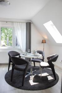 uma sala de jantar com uma mesa e cadeiras e uma janela em Heideträume Appartements em Undeloh