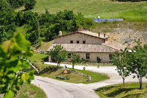 a house on a hill next to a road at AGRITURISMO LA VALLE DEI BRONZETTI in Cascia
