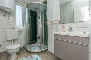 a bathroom with a shower and a toilet and a sink at Apartment Mandic in Omiš +21 photos
