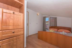a bedroom with a bed with a dresser and a window at Apartment Mandic in Omiš