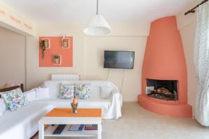 ein Wohnzimmer mit einer weißen Couch und einem Kamin in der Unterkunft Markella's House in Brauron