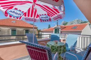 a table and chairs on a balcony with an umbrella at Apartment Mandic in Omiš