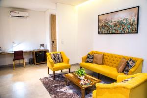 una sala de estar con 2 sofás amarillos y una mesa. en Hotel Pance 122 Wellness Spa, en Cali 37 fotos más