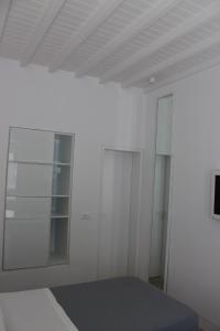 a room with a white wall and a white bed at Christina Studios in Mýkonos City