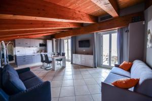 a living room with blue couches and a table and a kitchen at Altezza in La Morra