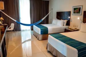 a hotel room with two beds and a hammock in it at Mesón de la Luna Hotel & Spa in Mérida