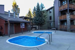 a small swimming pool in a courtyard next to a building at Mammoth Reservations in Mammoth Lakes