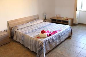 una camera da letto con un letto e un animale di peluche di Confortevole Appartamento a pochi passi dal Centro ad Alghero