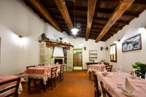 a dining room with tables and chairs and a fireplace at AGRITURISMO LA VALLE DEI BRONZETTI in Cascia