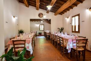 卡夏AGRITURISMO LA VALLE DEI BRONZETTI的宴会厅配有桌椅和粉红色的桌布