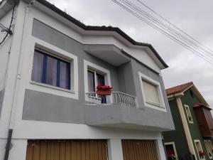 a house with a flower pot on a balcony at Casa Oviedo centro in Oviedo +8 photos