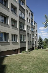 un edificio alto con un prato davanti di City Center Apartment in Siauliai a Šiauliai