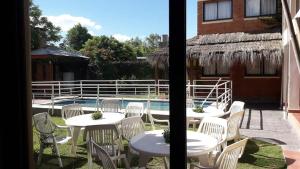 a patio with tables and chairs next to a pool at Residencial Sol del Champaqui in Mina Clavero