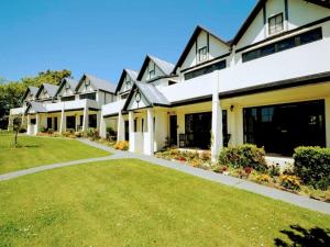 una casa grande con césped delante en Salty Dog Inn, en Snells Beach