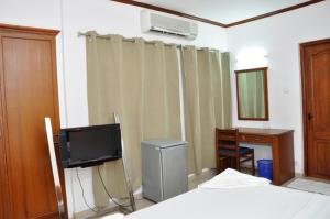 a bedroom with a tv and a bed and a desk at Sayoojyam Residency in Palakkad