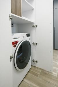 a washing machine in a room with a door at City Center Apartment in Siauliai in Šiauliai