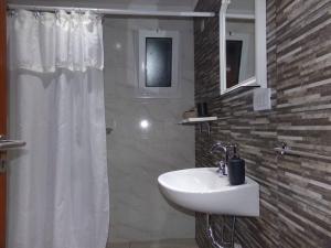 a bathroom with a white sink and a shower at Alma Cabaña de Mar in San Eduardo del Mar +50 photos