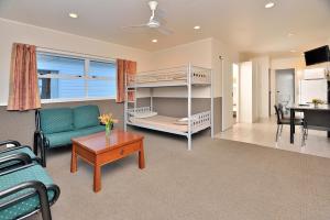 - un salon avec un canapé et des lits superposés dans l'établissement Auckland Northshore Motels & Holiday Park, à Auckland