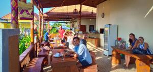 eine Gruppe von Menschen, die an Tischen in einem Restaurant sitzen in der Unterkunft Dream Beach Hostel Lembongan in Nusa Lembongan