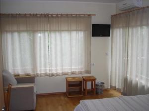 a bedroom with a bed and a window with curtains at Aisa Accommodation in Pärnu