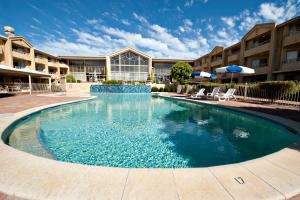 a large swimming pool in front of a building at Abbey Beach Resort in Busselton