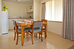 
a kitchen with a table and chairs and a refrigerator at Abbey Beach Resort in Busselton
