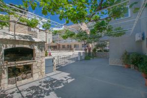 a patio with a stone fireplace next to a house at Apartment Anica in Omiš