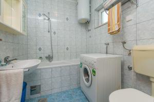 a bathroom with a washing machine and a sink at Apartment Anica in Omiš