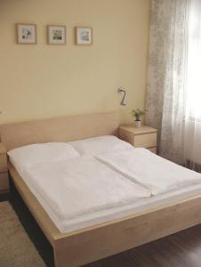 um quarto com uma cama grande e lençóis brancos em Hotel Saloon em Zlín