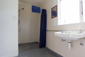 a bathroom with a sink and a shower at Sequoia Lodge Backpackers in Picton