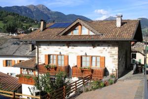 a white house with a brown roof at B.& B. Corradini in Castello di Fiemme