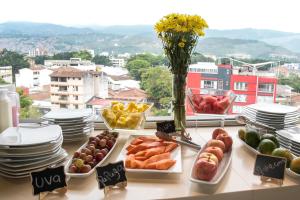 a buffet of food on a table with plates at Hotel Toscana Plaza in Cali