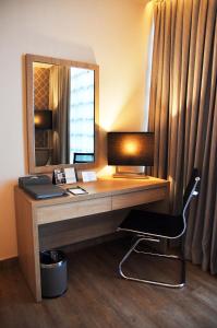 a desk with a mirror and a chair in a room at bai Hotel Cebu in Cebu City