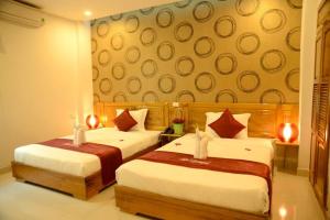 una habitación de hotel con 2 camas con velas en Red Diamond Hotel, en Da Nang
