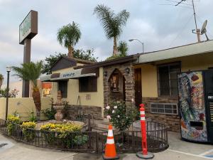 a restaurant with a building with palm trees at Apache Inn in Lynwood